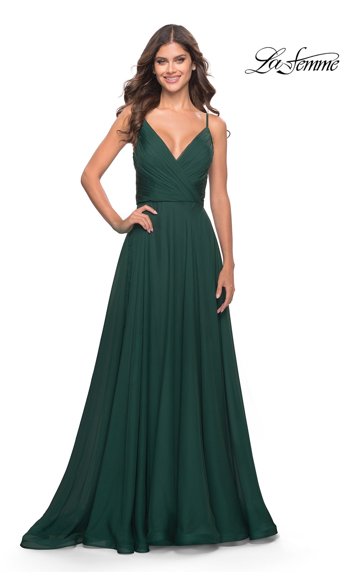 A woman models the La Femme V-Neck Long A-Line Prom Dress 31500 in floor-length dark green with spaghetti straps and a V-neckline, standing against a plain white background.